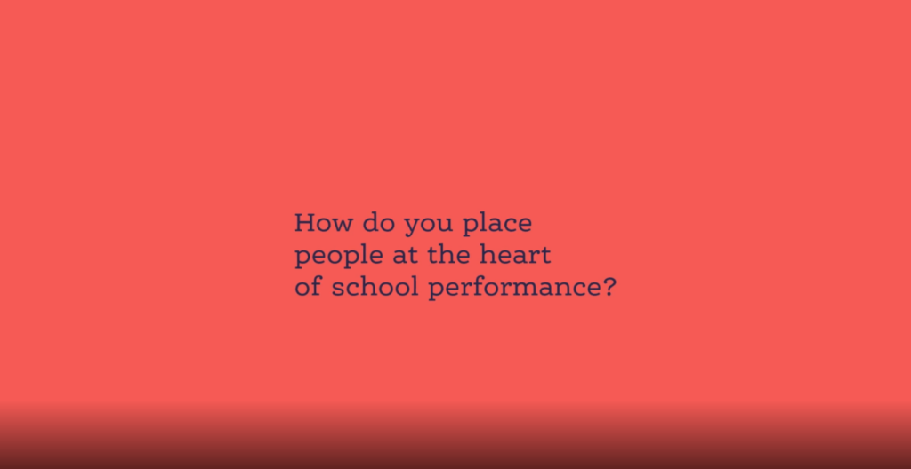 Simple pink background with the words - How do you place people at the heart of school performance? in blue.